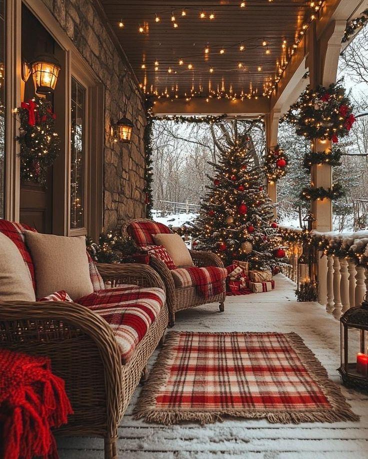 A snow-covered porch strung with warm lights, looking out onto a decorated Christmas tree in the garden